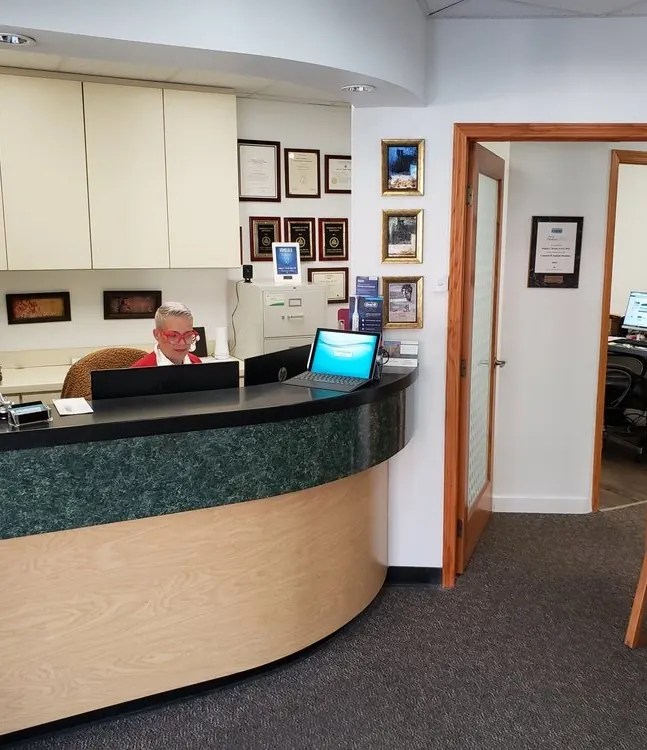 The curved reception desk at Hawaii Cosmetic Dental, with the doctor's office behind it.