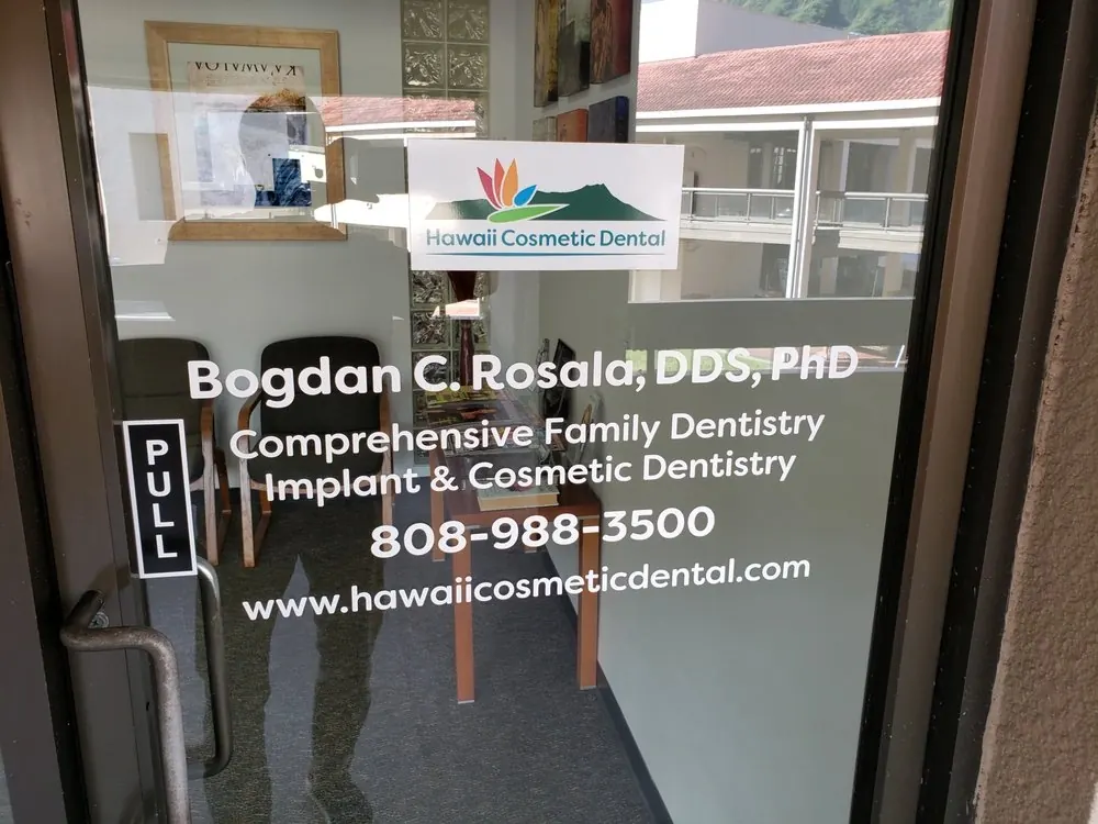 The glass entrance door of Hawaii Cosmetic Dental, lettered with Dr. Bogdan C. Rosala's name and the practice phone number.