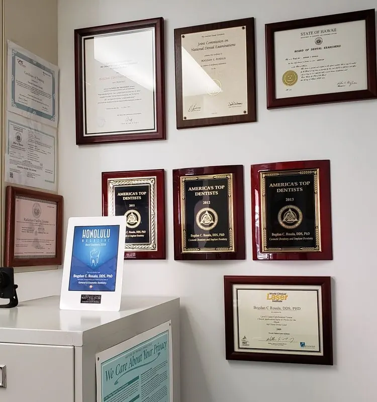 Dr. Rosala's framed diplomas, his State of Hawaii license and America's Top Dentists plaques on the office wall.