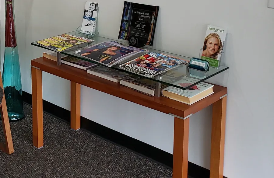 The reading table in the waiting room, beneath six Hawaiian portrait canvases.